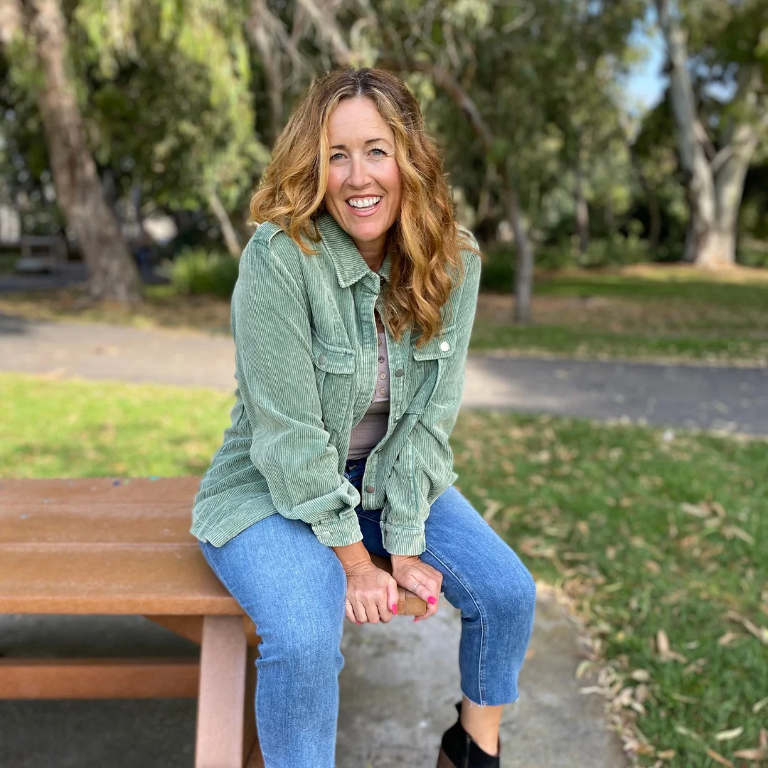 Diana Paquet smiling while sitting on a park bench